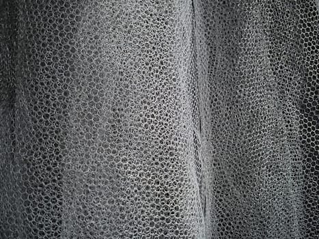 White wrinkled mesh fabric. A washable thing made of synthetic material. Mosquito net folded into soft folds. A bridal veil.
