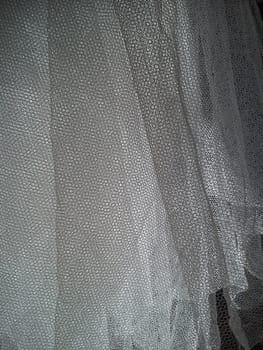 White wrinkled mesh fabric. A washable thing made of synthetic material. Mosquito net folded into soft folds. Fabric similar to a bridal veil.