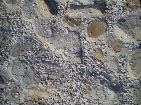 Stones connected by cement mortar. Small pebbles, sand and dust.