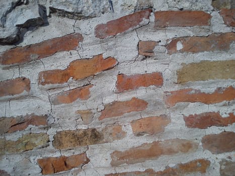 Old brick. The restored wall of the building of Roman times. Sunlight and warm brown-red shades of uneven bricks. Archaeological site in Serbia