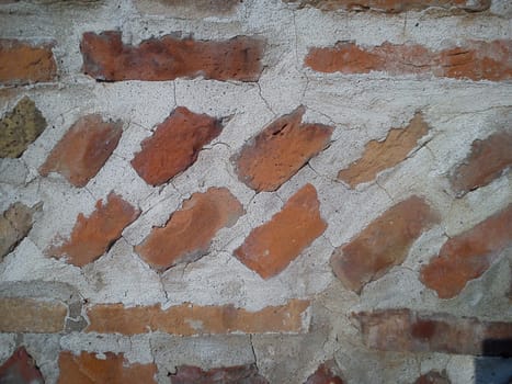Old roman brick. The restored wall of the building of Roman times. Sunlight, diagonal lines and warm brown-red shades of uneven bricks. Archaeological site in Serbia, Sremska Mitrovica.