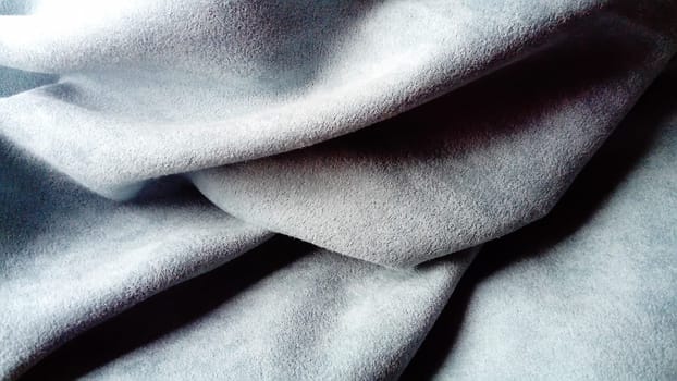 close-up of velvety thick fabric for curtains of gray and blue color pleated with the play of chiaroscuro