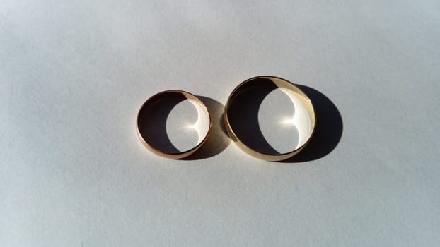Gold wedding rings, large and small, male and female. White background