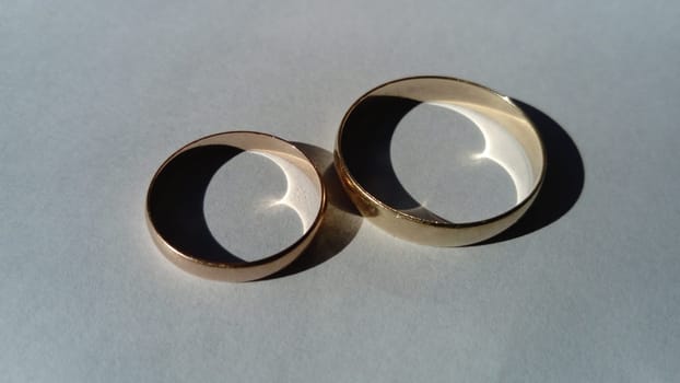 two wedding gold rings on a white background