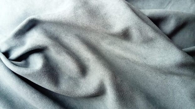 Canvas made of velvet fabric in gray, blue and asphalt. The fabric is laid in beautiful waves, reminiscent of a satire mask from afar. Theater curtain.