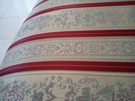 The lower part of the seat in the theater chair. Upholstery of upholstered furniture is made of beautiful material with floral and floral patterns and red stripes