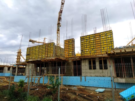 Sremska Mitrovica, Serbia. June 10, 2020. Construction of an apartment building under the state program for refugees, police and military personnel. Construction work on the ground floor. Building materials and crane