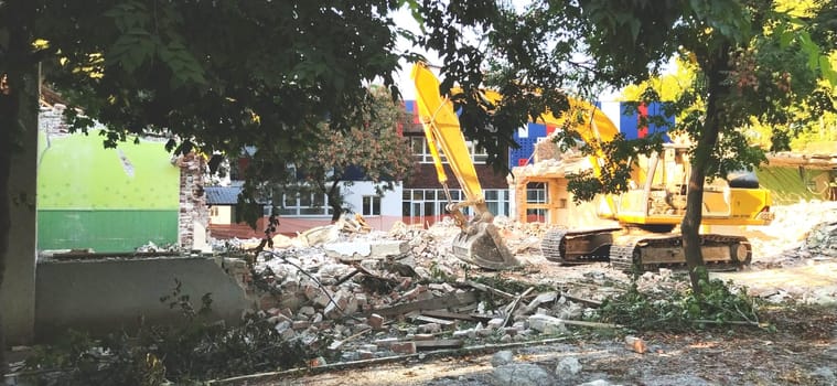 Sremska Mitrovica, Serbia, 13 August 2020. Dismantling and demolition of the old school named after Jovan Popovic. Pieces of concrete, rebar are hanging. Bulldozers are breaking down walls