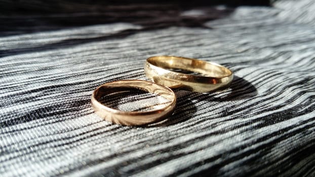 two gold rings, on a gray background