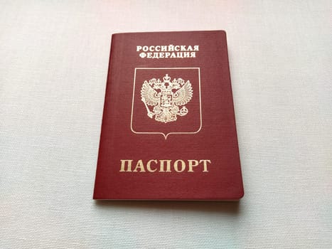 Passport of a citizen of the Russian Federation. International passport for travel and border crossing. Burgundy document cover with embossed gold letters. White background from textile.
