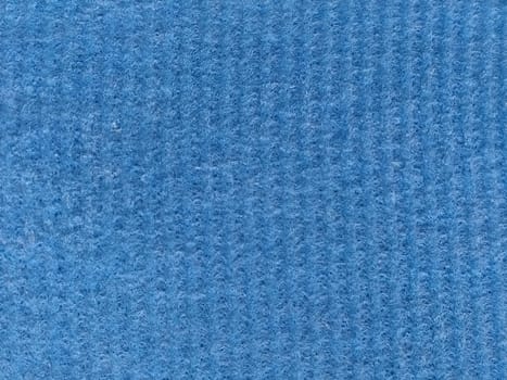 Close-up of a striped fabric with raised printing. Vertical stripes on blue microfiber or sponge.