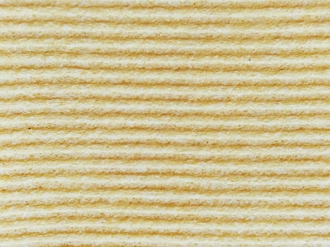 Close-up of a striped fabric with raised printing. Horizontal stripes on yellow microfiber or sponge