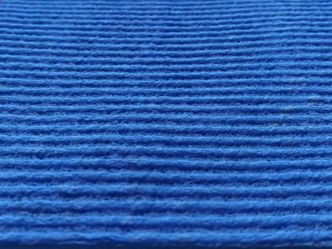 Blue striped ribbed fabric. Close-up shot of a dish washing sponge or microfiber cloth. Blur around the edges.