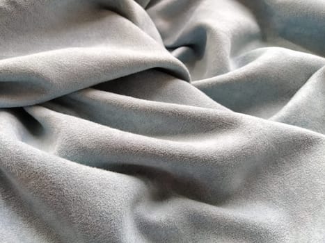 Fabric sheer curtain fabric. Beautiful gray-blue color. Soft velvet with a pile. The curtain material is carelessly folded and wrinkled on a horizontal surface. Fabric sample. Interior design option.
