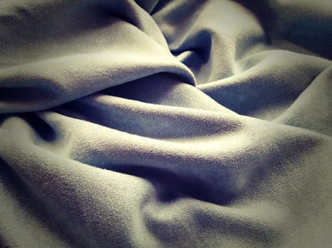 Cloth Curtain. Beautiful gray-blue color. Soft velvet with velvet. Curtain material folds casually on a horizontal surface. Sample fabric for the interior.Dark vignetting around the edges of the image