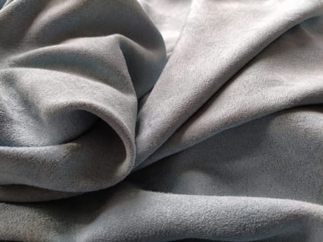 Fabric sheer curtain fabric. Beautiful gray-blue color. Soft velvet with a pile. The curtain material is carelessly folded and wrinkled on a horizontal surface. Fabric sample. Interior design option.