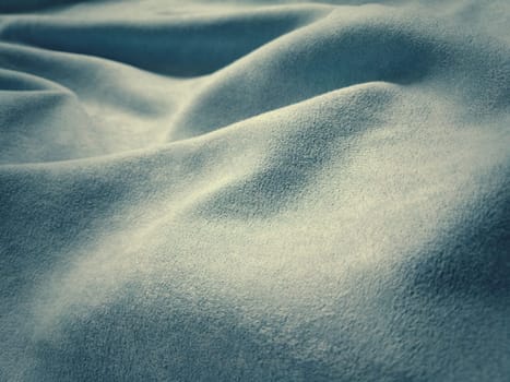 Fabric sheer curtain fabric. Beautiful blue color. Soft velvet with a pile. The curtain material is carelessly folded and wrinkled on a horizontal surface. Fabric sample. Interior design option