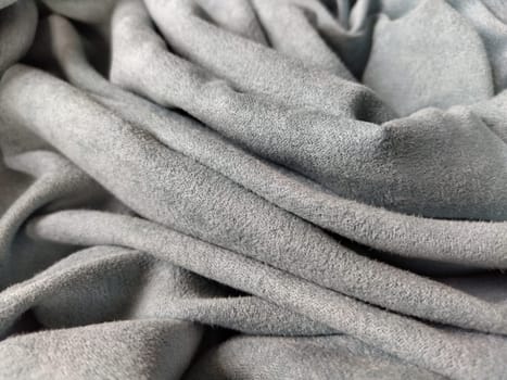 Fabric sheer curtain fabric. Beautiful gray-blue color. Soft velvet with a pile. The curtain material is carelessly folded and wrinkled on a horizontal surface. Fabric sample. Interior design option.