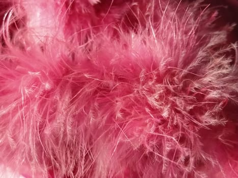 Pink faux fur or pink colored natural bird feathers close-up. Light feathers boa. Delicate texture. Greeting card Happy Valentines Day. Collar from a women's or girl's jacket. Bright pink or color.