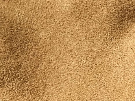beige suede fabric. Close-up of a faux suede or nubuck fabric. Sewing accessories and fabrics. Short pile texture