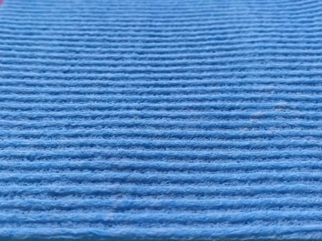 Blue striped ribbed fabric. Close-up shot of a dish washing sponge or microfiber cloth. Blur around the edges.