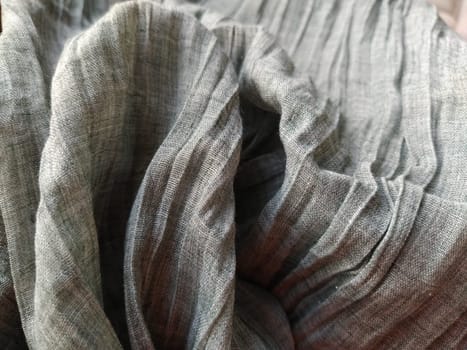 Fabric sheer curtain fabric. Beautiful gray color. The curtain material is carelessly folded and wrinkled. Fabric sample. Interior design option.