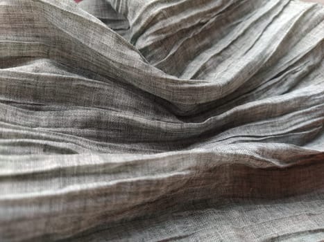 Fabric sheer curtain fabric. Beautiful gray color. The curtain material is carelessly folded and wrinkled. Fabric sample. Interior design option.