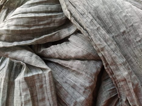 Fabric sheer curtain fabric. Beautiful gray color. The curtain material is carelessly folded and wrinkled. Fabric sample. Interior design option.