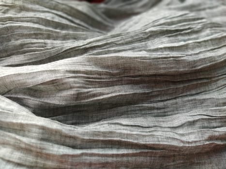 Fabric sheer curtain fabric. Beautiful gray color. The curtain material is carelessly folded and wrinkled. Fabric sample. Interior design option.