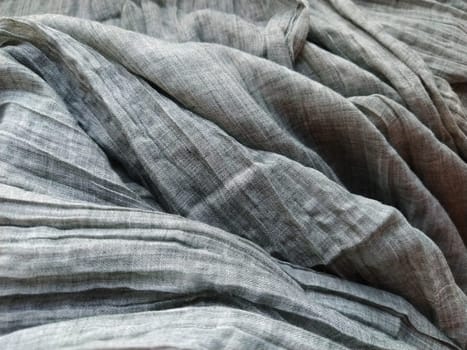 Fabric sheer curtain fabric. Beautiful gray color. The curtain material is carelessly folded and wrinkled. Fabric sample. Interior design option.