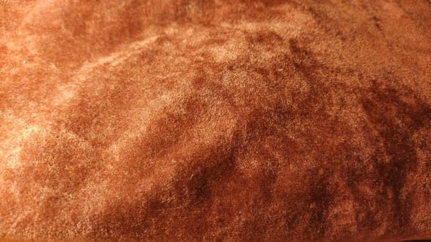 Red velvet. Close-up. Velvet fabric texture. Irregularities and overflows of light. Deep, rich, chocolate couloured satin. Folded and flowing background