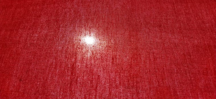 Sun or lamp through red blackout curtains. Bright red background with a glowing circle. Counter light