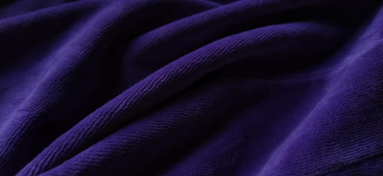 Blurred purple textile background. Soft smooth lines, velvety fabric structure. Black and purple colors.