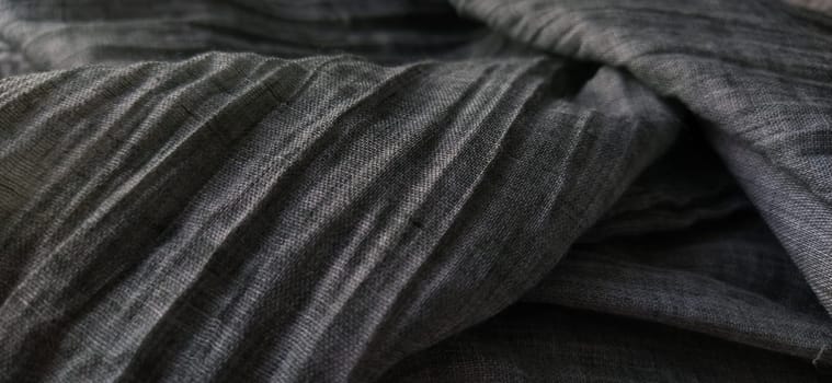Gray pleated fabric or crumpled textile closeup. Light translucent curtains or tulle in the Scandinavian style. Soft focus.