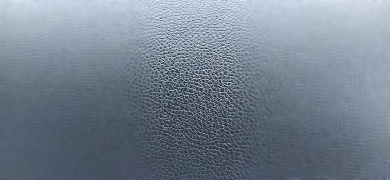 Black leather banner background with rich texture detail. close-up of black leather. A blurred background around the edges of the image. Artificial leather or polyester.