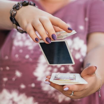 Female hands with bracelet and purple nails throw deck of tarot cards in air. Minsk, Belarus, 28.07.2021
