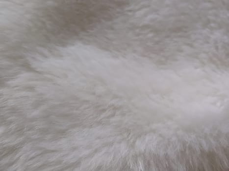 White faux fur. Close-up. Partially defocused photo. Fluffy villi.