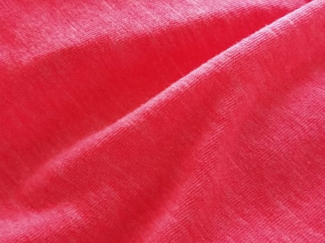 Bright pink or magenta polyester fabric, wrinkled or folded carelessly. Saturated background. Defocused photo around the edges of the photo