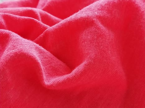 Bright pink or magenta polyester fabric, wrinkled or folded carelessly. Saturated background. Defocused photo around the edges of the photo