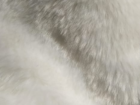White faux fur. Close-up. Partially defocused photo. Fluffy villi.