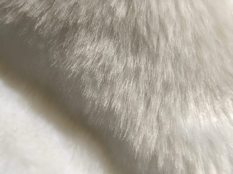 White faux fur. Close-up. Partially defocused photo. Fluffy villi.