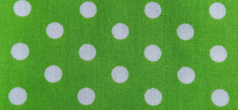 Belgrade, Serbia, 11 September 2020 Green fabric with polka dots. White circles. Close-up. Fabric for sewing dresses and home furnishings. Banner.