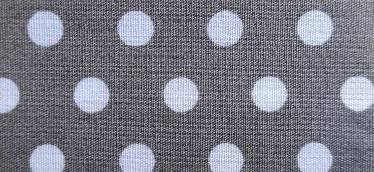 fabric white polka dots on a gray background, smoothed flat surface.