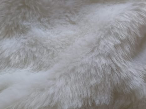 White faux fur. Close-up. Partially defocused photo. Fluffy villi.