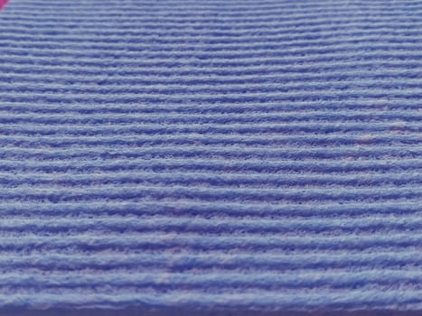 lilac or purple striped ribbed fabric. Close-up shot of a dish washing sponge or microfiber cloth. Soft focus.