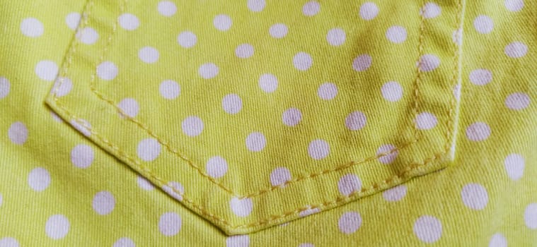 Belgrade, Serbia, 11 September 2020 Trouser pocket. Yellow cloth with white circles. Pockets on denim. Polka dot fabric.