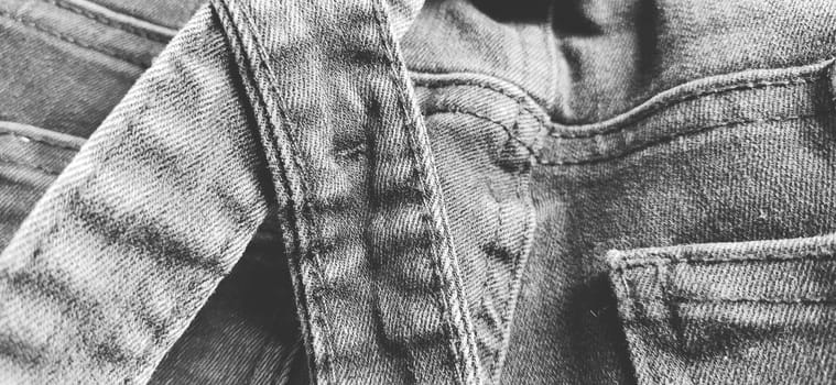 Fashionable denim clothing. Details and seams on rough denim. Black and white photography.