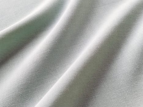 Beautifully folded fabric. Soft pleasant waves and flounces on textiles. Close-up. Drapery for curtains, fabric for dressmaking or upholstery. Black and white monochrome image