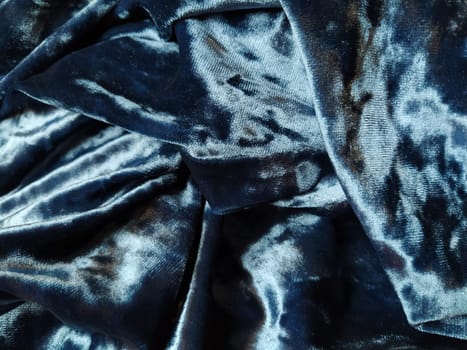 Velvet velor cloth background with glowing light and dark shadows. Background for theater and fashion design themes. Nice blue fabric with overflow.
