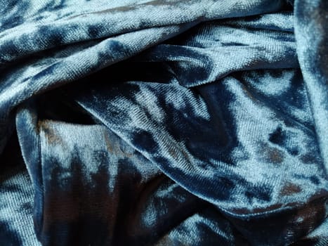 Velvet velor cloth background with glowing light and dark shadows. Background for theater and fashion design themes. Nice blue fabric with overflow.